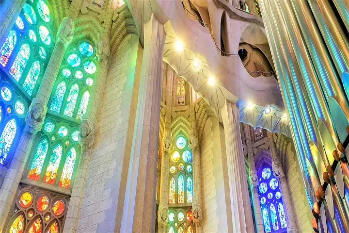 Colorful stained glass windows illuminate the interior of Sagrada Familia, emphasizing its breathtaking design.