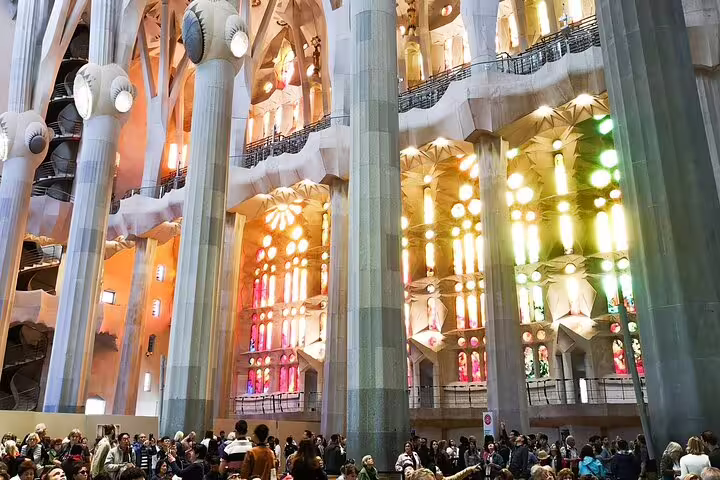 Visitors admire the vibrant stained glass and towering columns inside Gaudi's iconic Sagrada Familia on a guided tour.