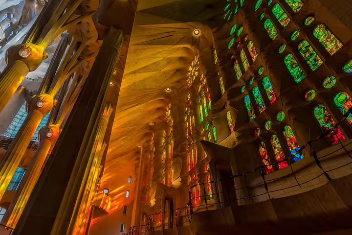 Colorful stained glass windows inside Sagrada Familia cast vibrant light on the cathedral's ornate interior.