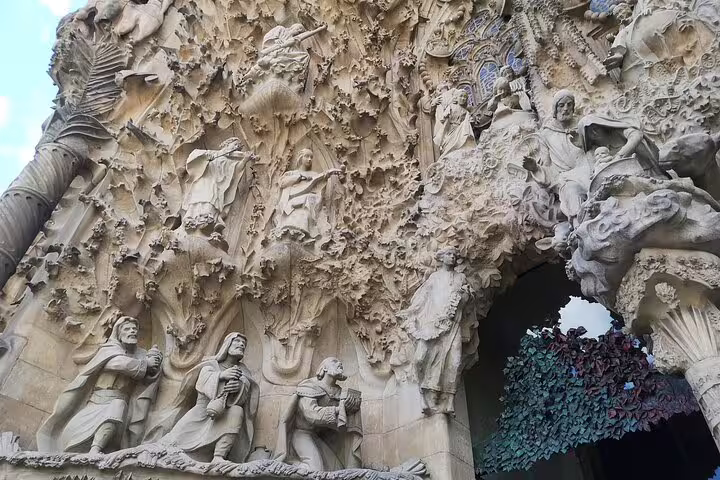 Intricate stone carvings on the facade of Sagrada Familia, showcasing its architectural detail on a skip-the-line tour.