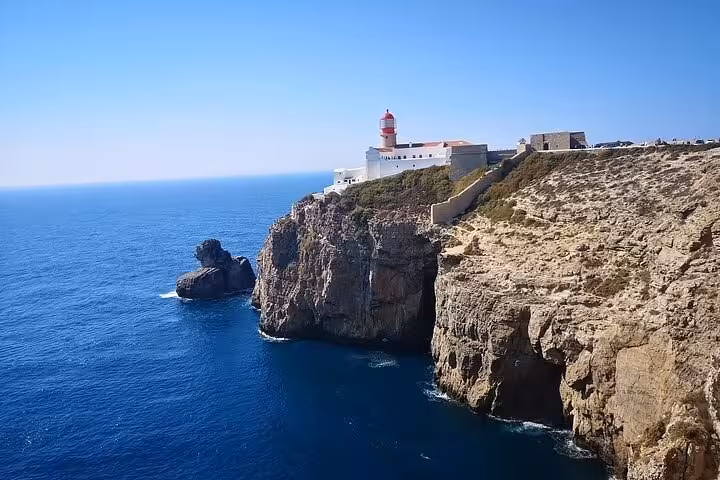 Sagres lighthouse perched on dramatic Algarve sea cliffs above the Atlantic Ocean, a highlight of Lagos & Sagres tour