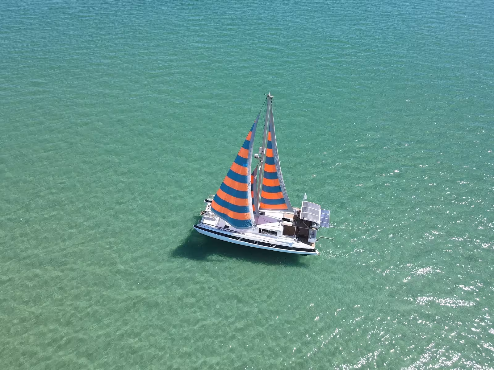 Aerial view of sail catamaran in crystal-clear Blue Lagoon waters on full-day catamaran cruise and snorkeling