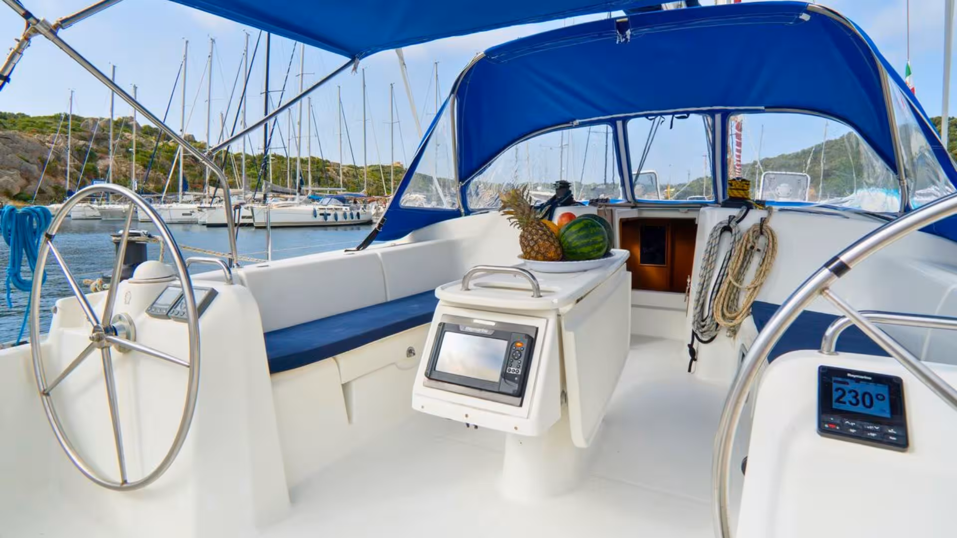 Cockpit of a sailboat in Santa Teresa di Gallura, equipped with navigation tools and fresh fruit, ideal for tours.