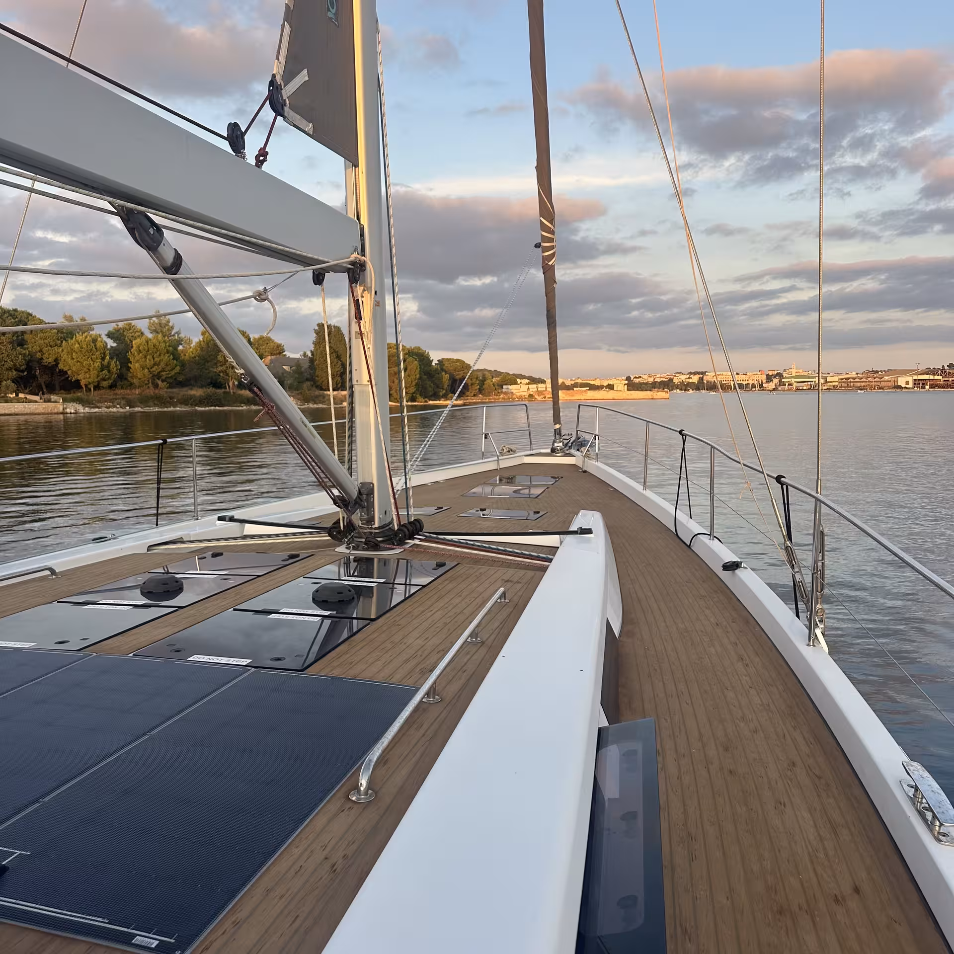 View from sailboat deck at sunset on calm water, ideal for Introduction to Sail online training and sailing basics