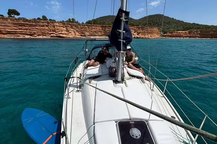 Sailboat anchored near Ibiza's scenic coastline, offering a relaxing private day trip experience to Formentera's crystal-clear waters.