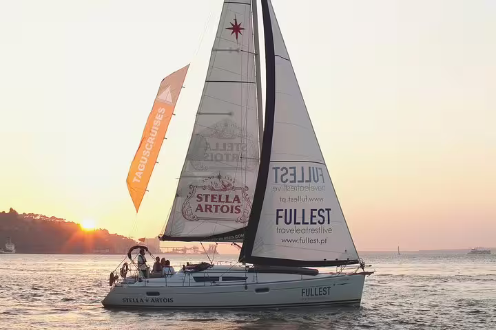 Sailboat on the Tagus River at sunset, offering a serene view of Lisbon's skyline.