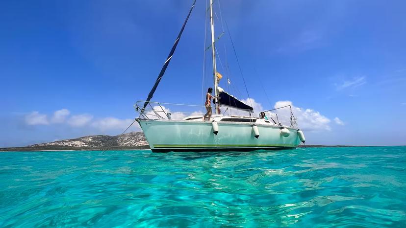 Sailboat anchored in Asinara's turquoise sea, offering a serene and picturesque sailing experience from Stintino.