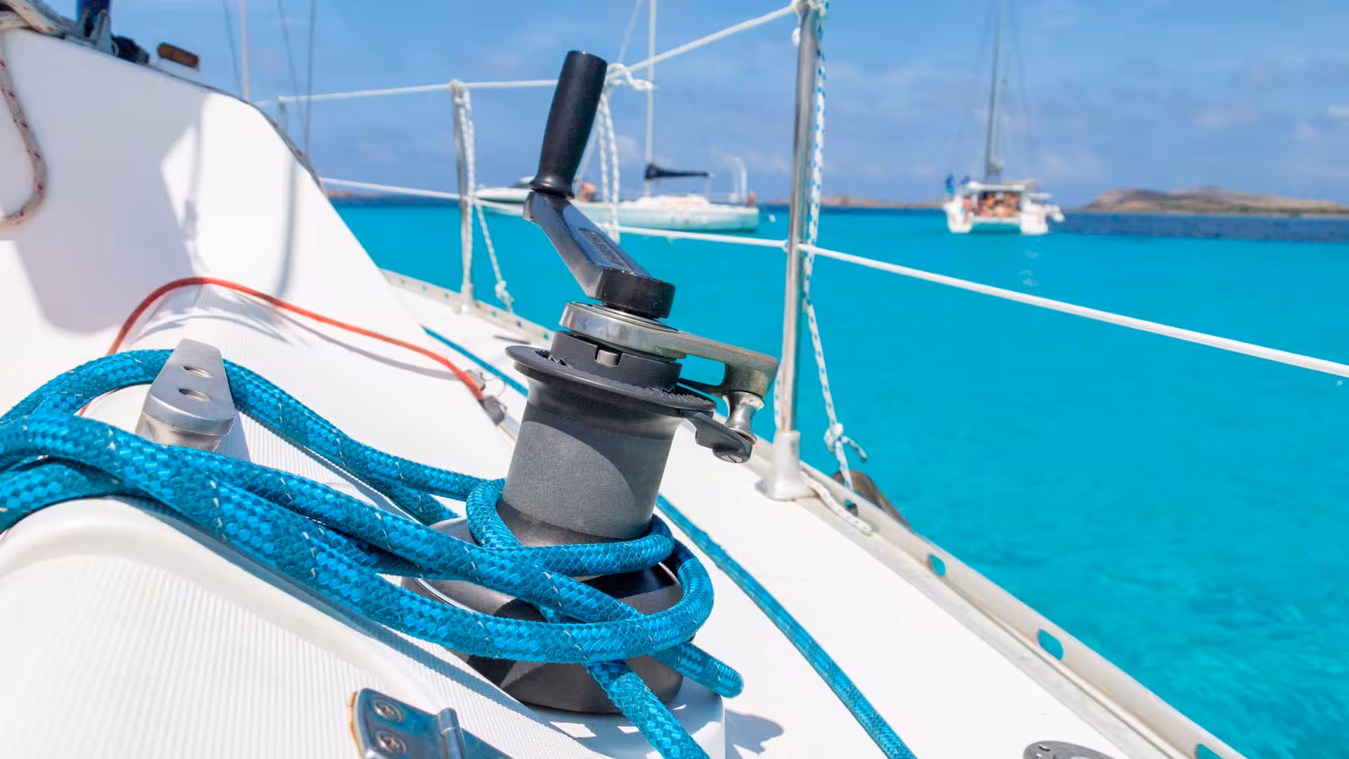 Close-up of a winch and blue rope on a sailboat with turquoise sea views on the Asinara sailing tour.