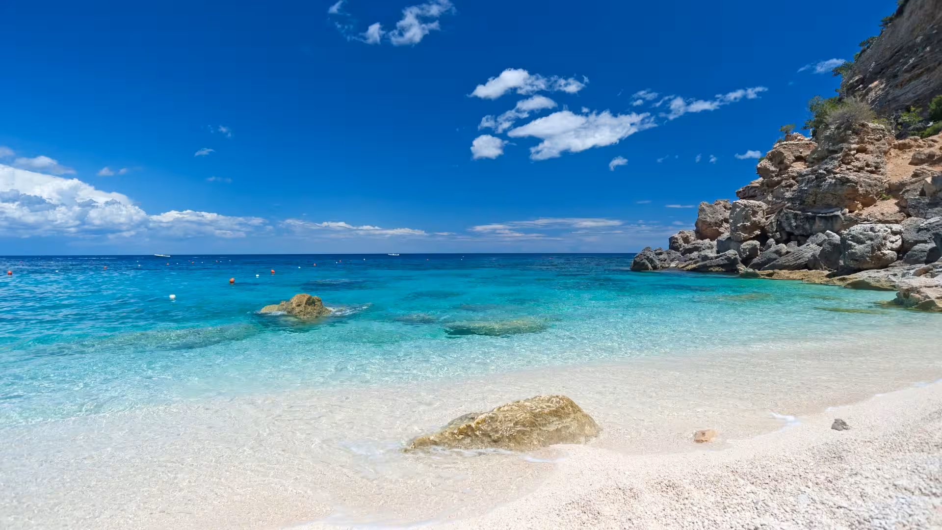 Crystal-clear waters and rocky shoreline of a secluded beach in the Gulf of Orosei near Cala Gonone.