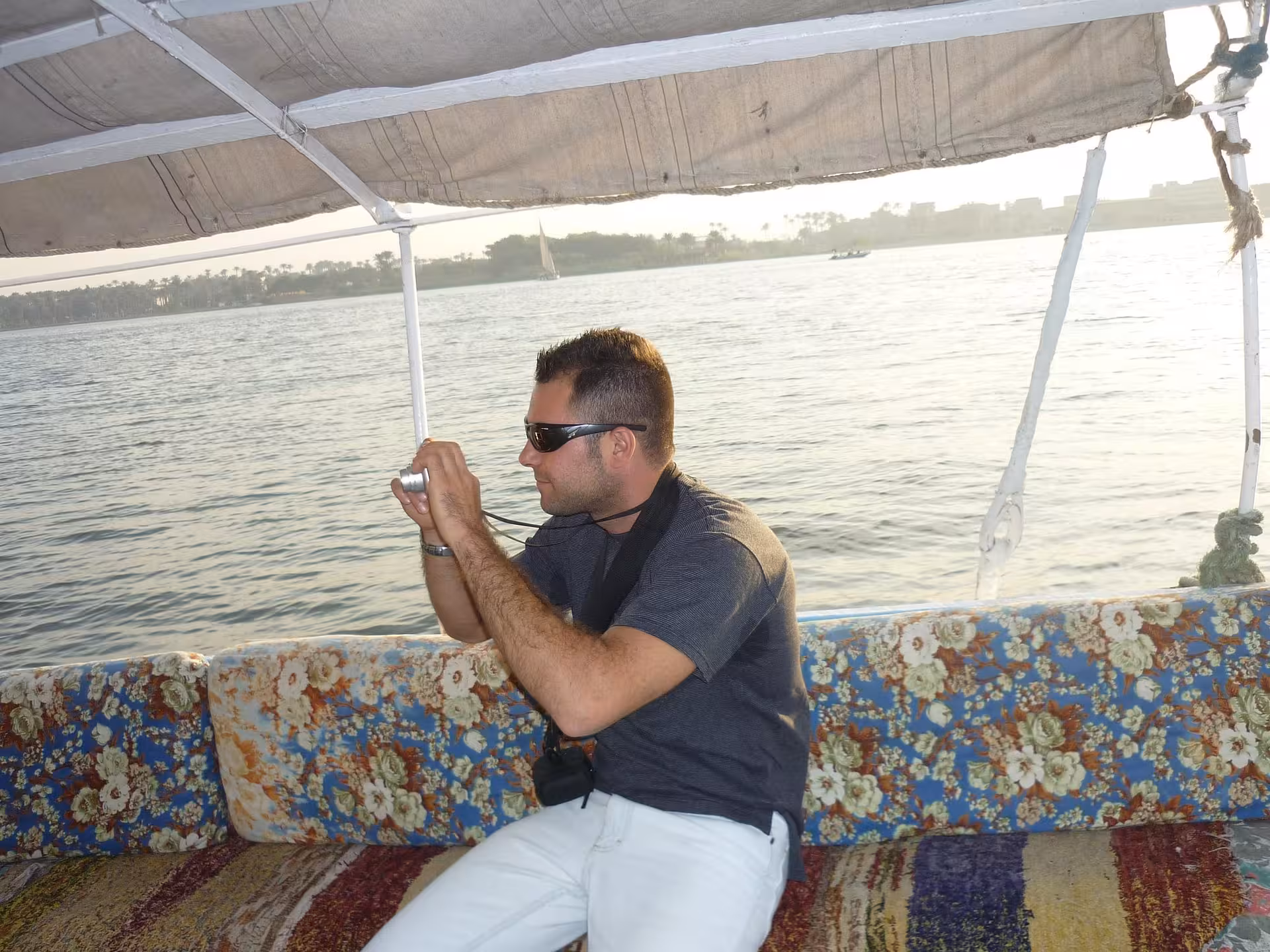Guest photographing views on a sailing felucca on the Nile in Cairo, daytime cruise with lunch and transfer