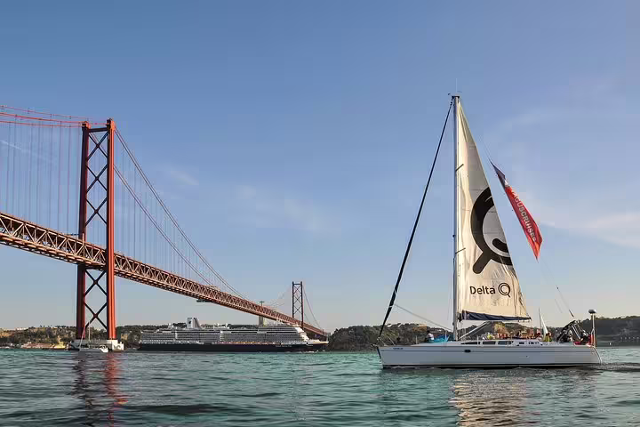 Sailing tour in Lisbon with a view of 25 de Abril Bridge and a cruise ship, capturing the beauty of the Tagus River.