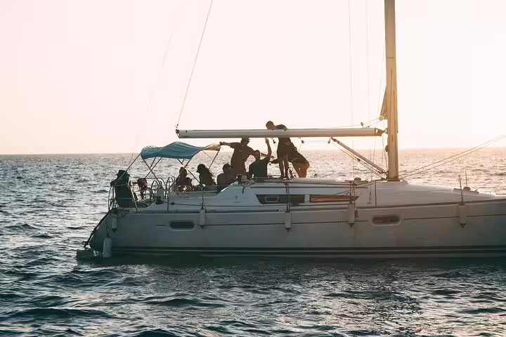 Group on a sailing yacht under sunset skies, capturing the essence of a private yacht charter adventure.