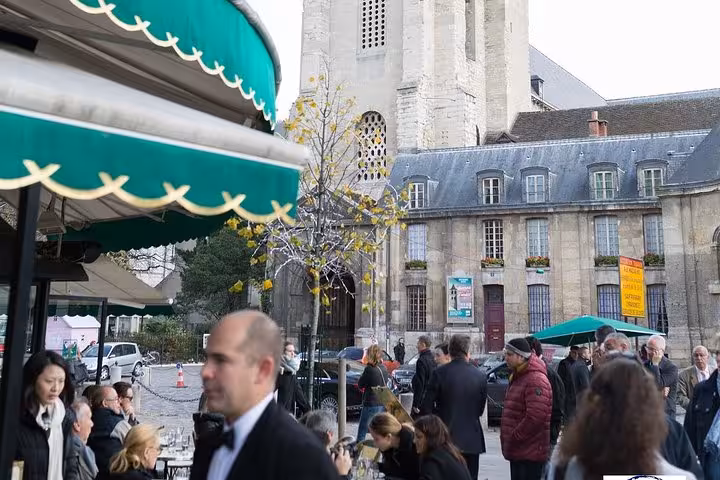 Tourists enjoy a bustling cafe scene in the heart of Saint Germain, highlighting the vibrant Parisian dining culture.