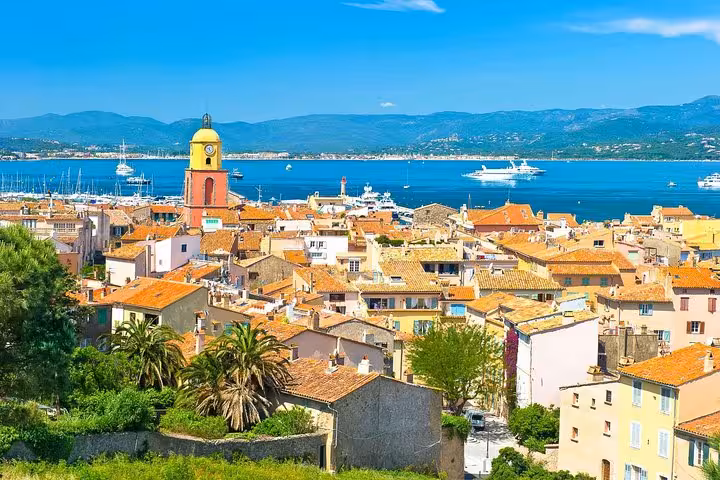 Scenic view of Saint-Tropez with its iconic bell tower and azure sea, perfect for a cultural exploration tour.