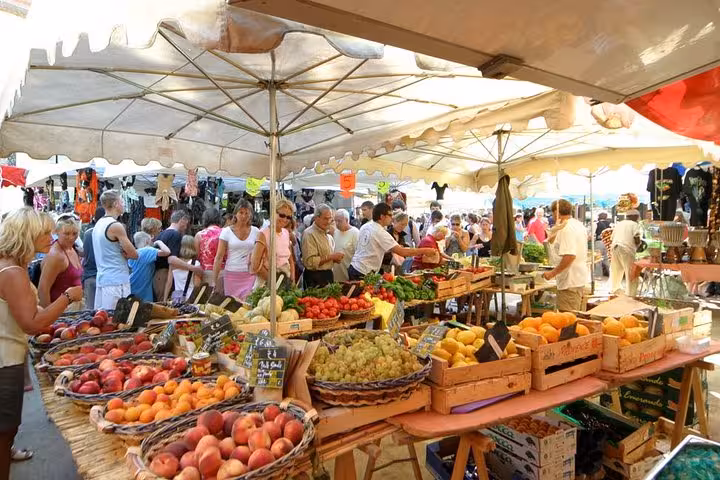 Vibrant market scene in Saint-Tropez with fresh produce and bustling crowds, perfect for a private day tour.