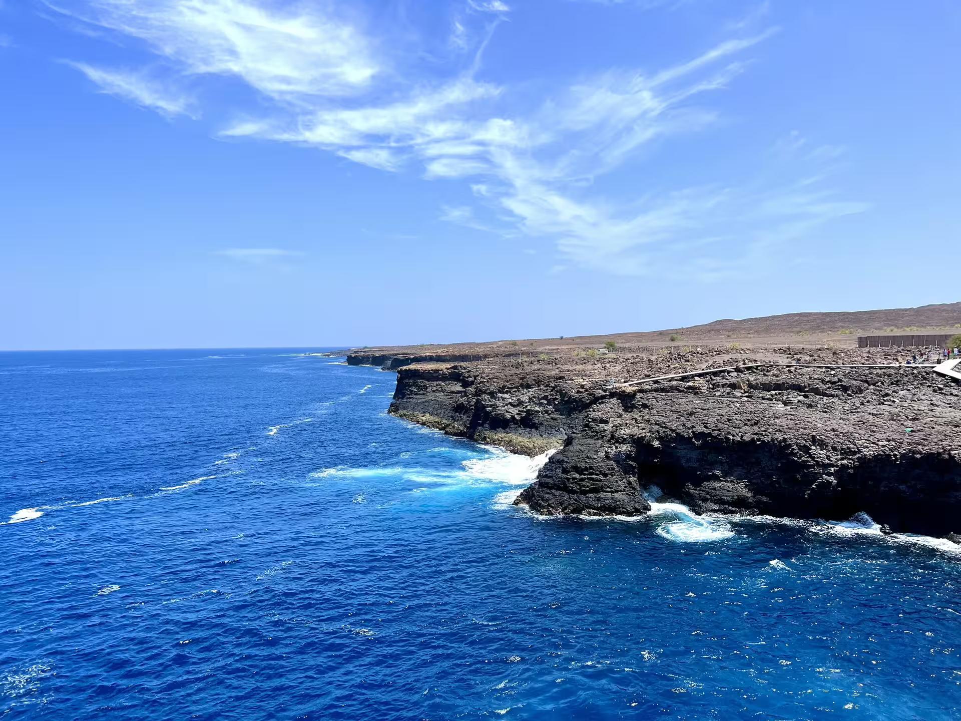 Rocky cliffs and vibrant blue ocean under sunny skies on Sal Island's scenic coastline tour.