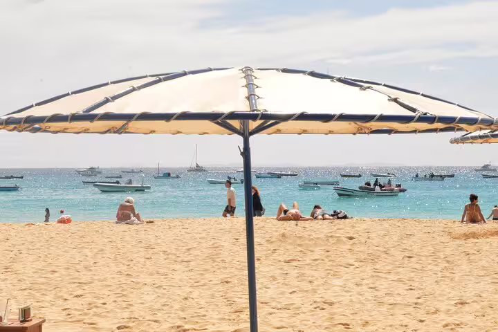 Sunny Santa Maria beach on Sal Island with parasol and boats, Cabo Verde airport to Espargos private transfer