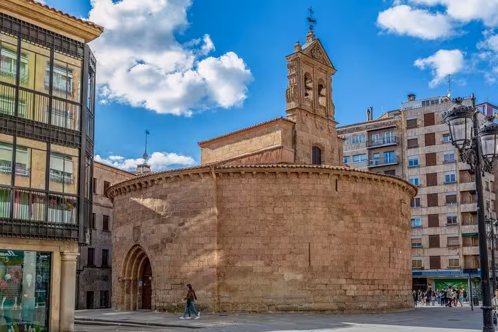 Historic Romanesque church in Salamanca city center with distinctive circular architecture and blue skies.