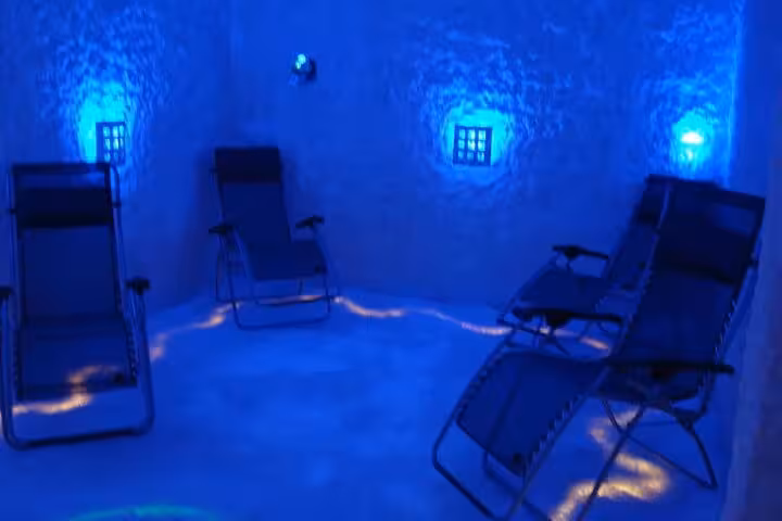 Relaxing salt therapy chamber with recliner chairs and blue lights in Sharm El Sheikh salt cave experience