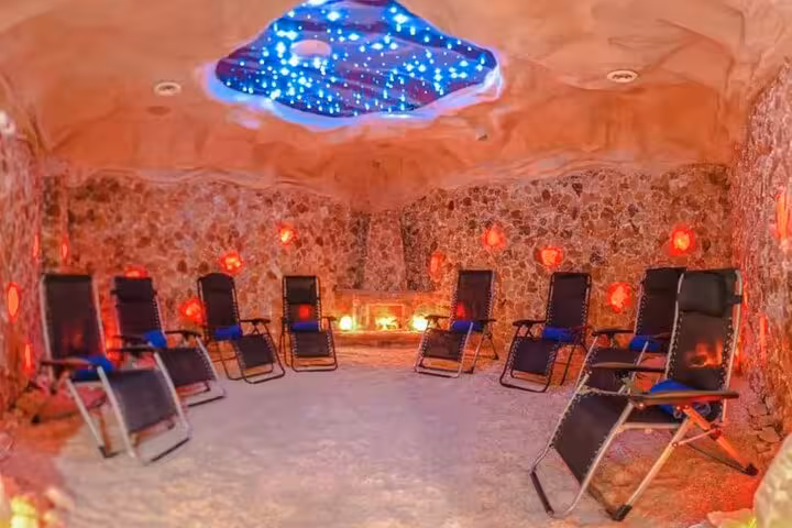 Salt therapy lounge in Sharm El Sheikh with recliner chairs and glowing salt lamps for relaxing wellness experience