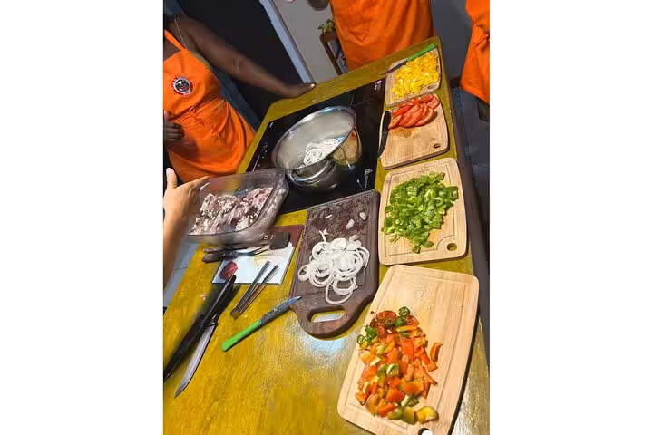 Participants preparing Bahian dishes with fresh ingredients in a vibrant cooking class in Salvador.