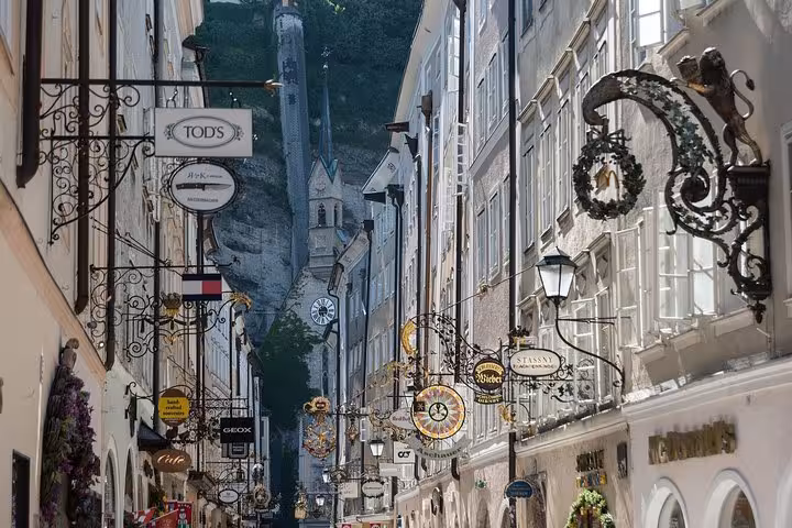 Salzburg Getreidegasse shopping street with ornate signs, stop on private Vienna to Salzburg Hallstatt Melk day tour