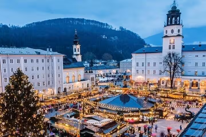 Salzburg Cathedral Square Christmas market at dusk, festive lights and towers on a Vienna private day trip