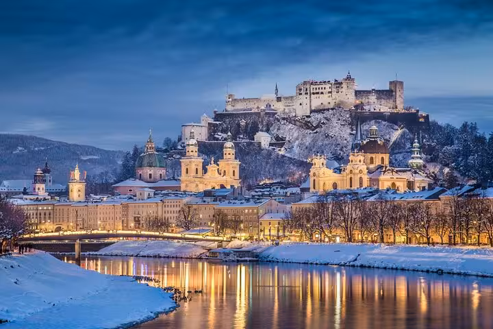 Winter twilight view of Salzburg Old Town and Hohensalzburg Fortress on a small-group day trip from Vienna