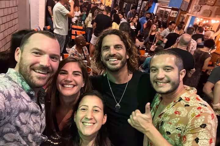 Group of friends smiling and embracing at a lively Samba Night Experience in Lapa, showcasing a vibrant atmosphere.