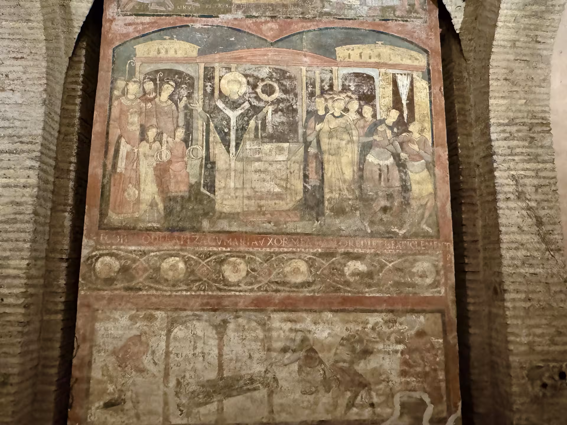 Faded medieval fresco of religious figures inside the hidden underground basilica at San Clemente, Rome