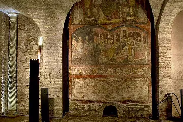 Ancient fresco and brick archway in the underground levels of San Clemente Basilica, illuminated on a private Rome tour