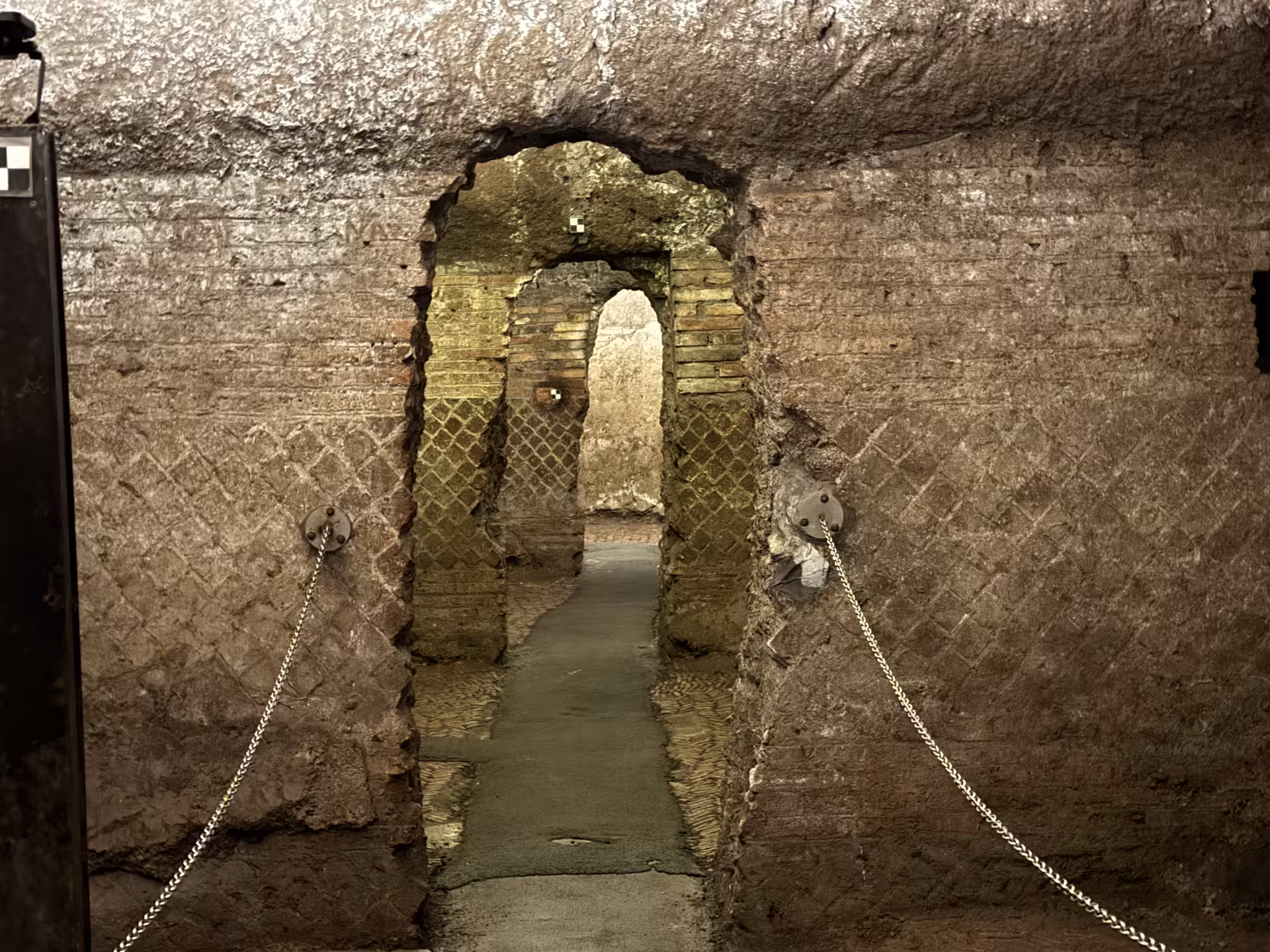 Narrow underground passage and brick archways in the hidden Roman ruins beneath Basilica di San Clemente in Rome, Italy