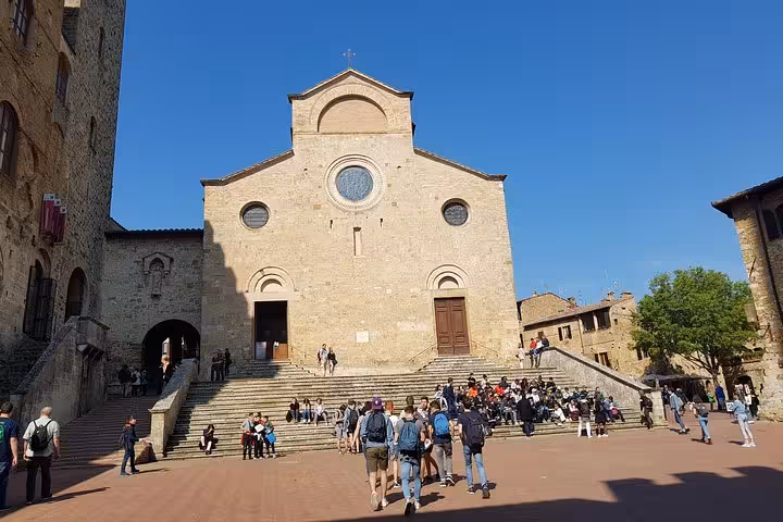 San Gimignano cathedral square on private Tuscany tour, Romanesque church facade and lively medieval piazza