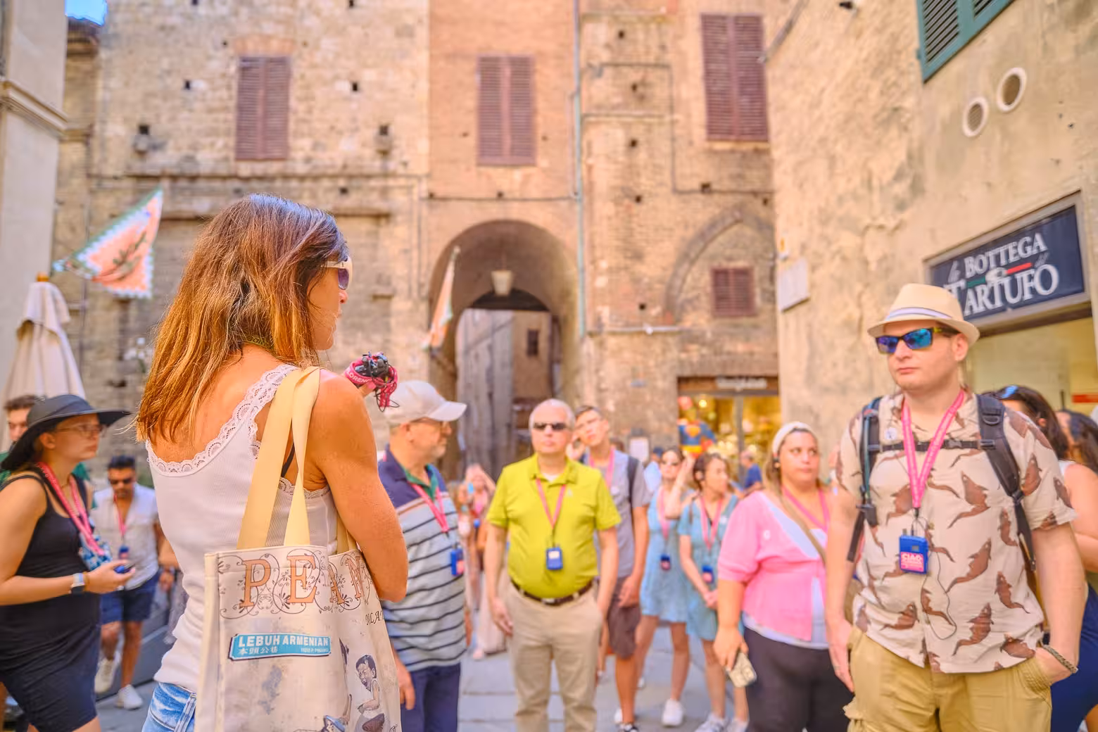 Visitors stroll through the charming streets of San Gimignano, admiring medieval architecture on a guided tour.