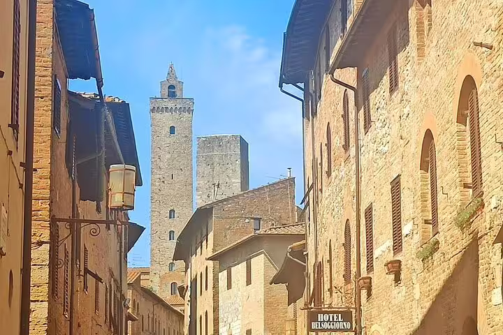 Medieval stone towers and narrow alleys of San Gimignano on a sunny day, visited on the private Volterra & San Gimignano tour