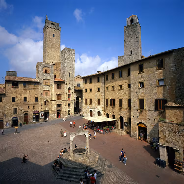 Charming San Gimignano square with medieval towers, a key stop on the Tuscany supercar adventure.