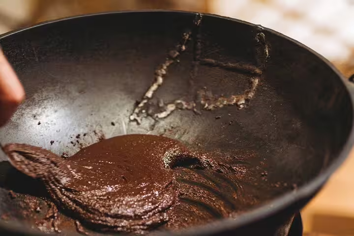 Thick, rich chocolate mixture being prepared in a pan on a San Jose culinary walking tour.