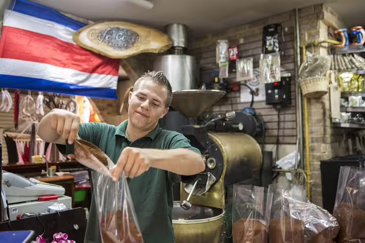 Local vendor in San Jose prepares coffee bags, showcasing Costa Rican flavors on a food tour.