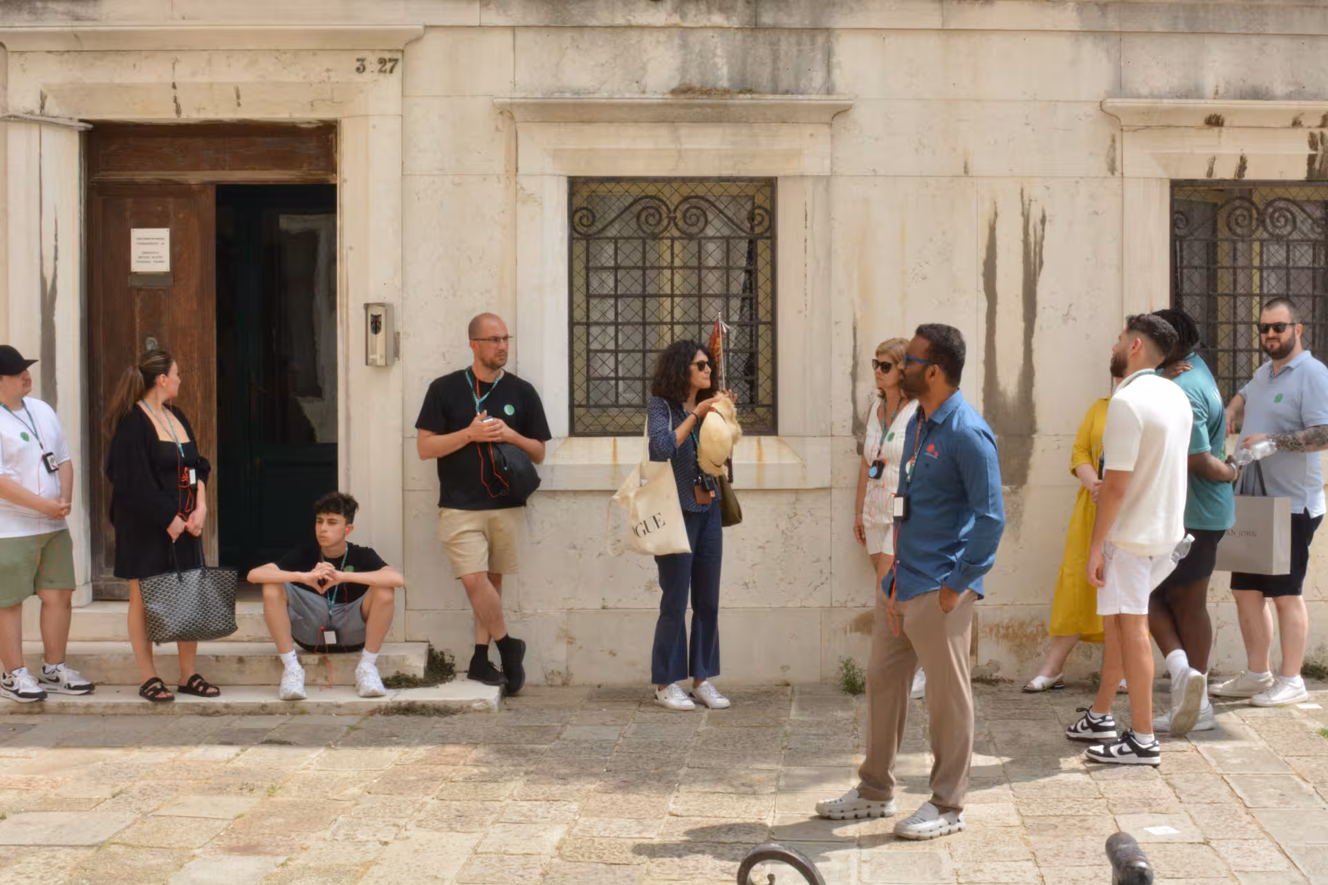 Group of tourists exploring a quaint Venetian alley, part of the San Marco to Rialto guided walk.