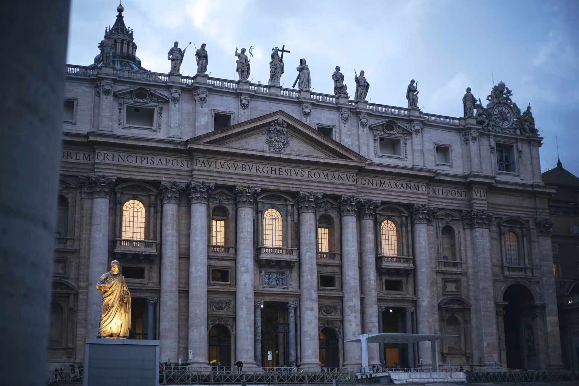 Illuminated facade of St. Peter's Basilica at dusk, highlighting the grandeur of Vatican City on a San Pietro Basilica Combo Tour.
