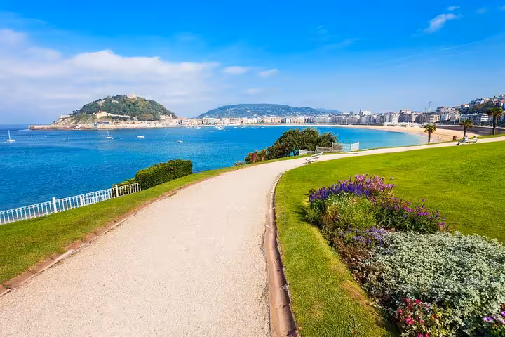 Scenic view of La Concha Bay from a lush park pathway in San Sebastian, ideal for a private city walk tour.