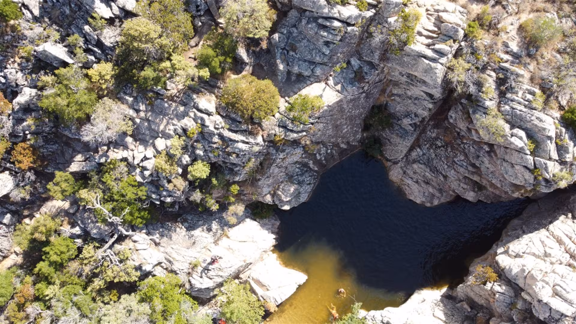 Aerial view of Rio Pitrisconi's rocky gorge with emerald pools, highlighting the rugged beauty of San Teodoro jeep tours.