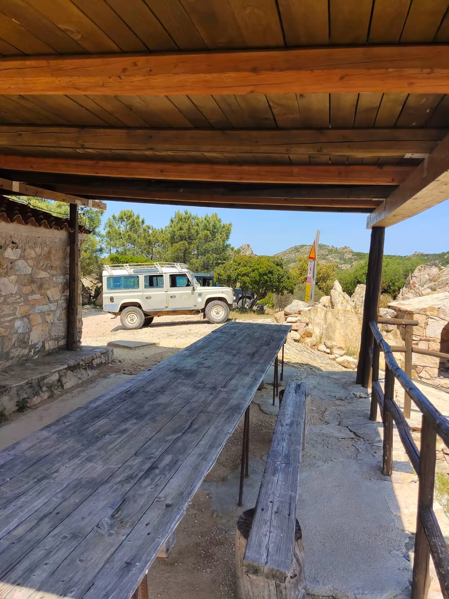 Rustic picnic area with a parked jeep in San Teodoro, offering a serene spot to relax during the Rio Pitrisconi tour.