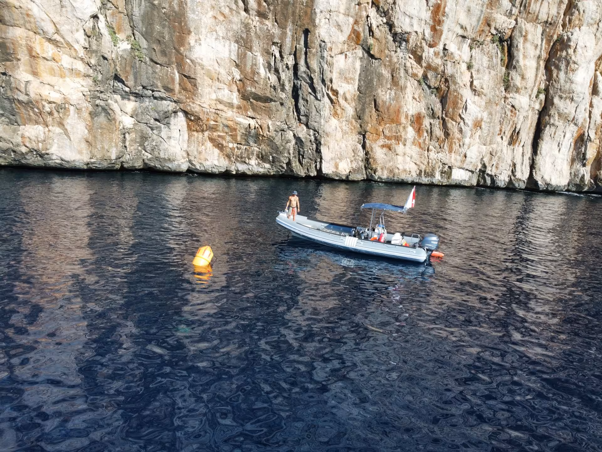 A small boat anchored near Molara's rocky cliffs, perfect for snorkeling adventures in San Teodoro.