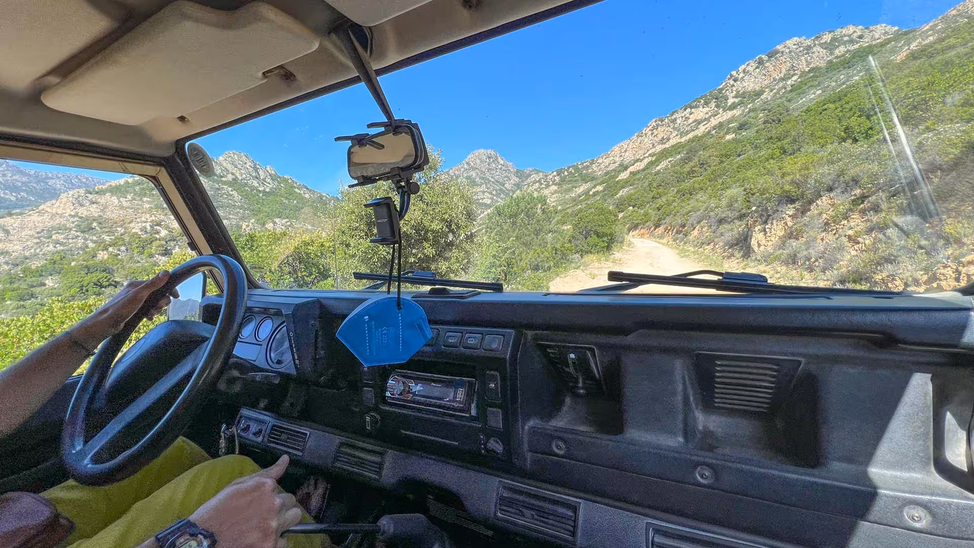 View from inside a jeep navigating rocky paths in San Teodoro's Rio Pitrisconi during a canyoning adventure.