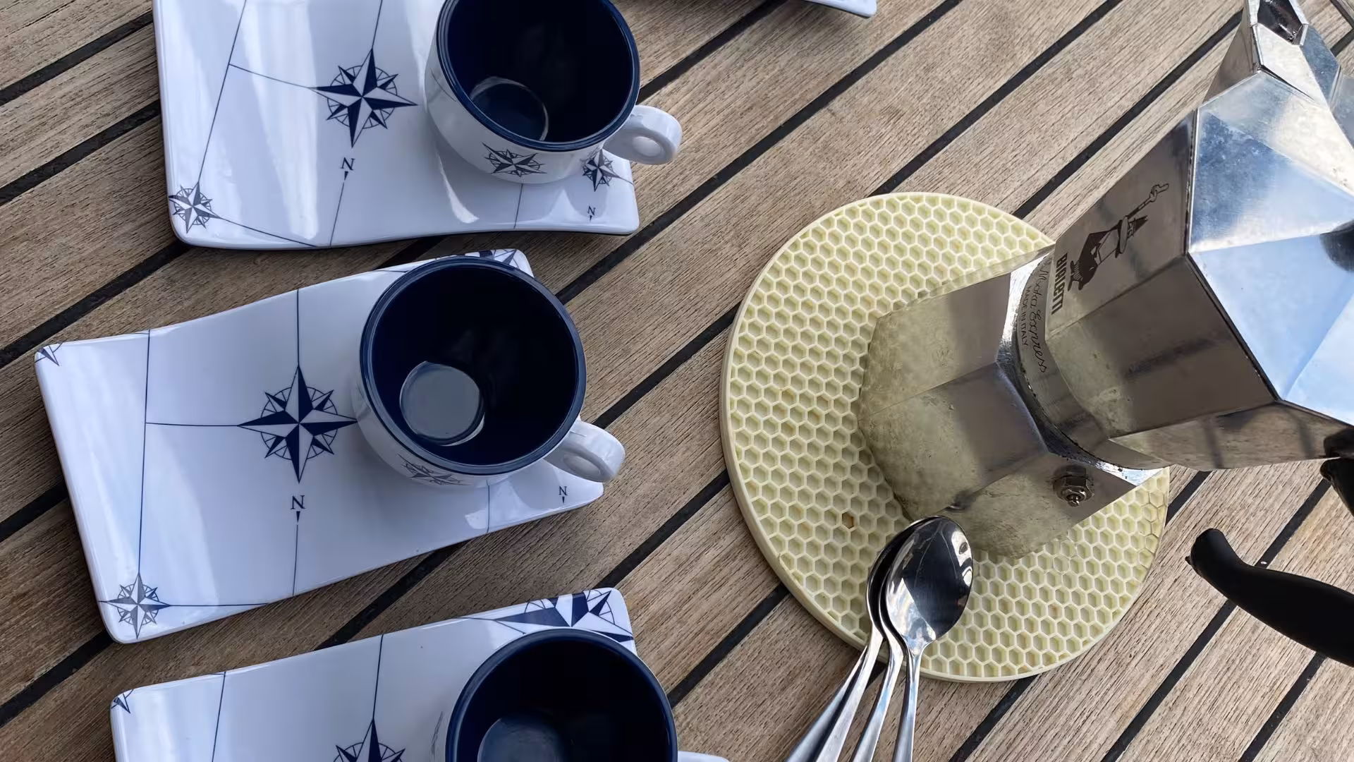 Coffee setup with nautical-themed cups on a sailing boat deck, perfect start to a San Teodoro tour.