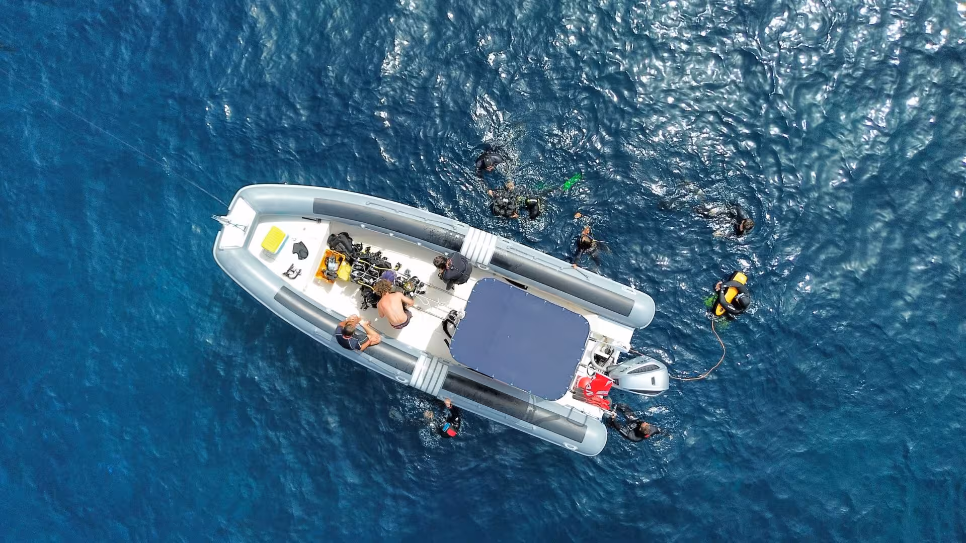 Aerial view of a boat with snorkelers diving in the clear waters near Tavolara, perfect for San Teodoro snorkeling tours.