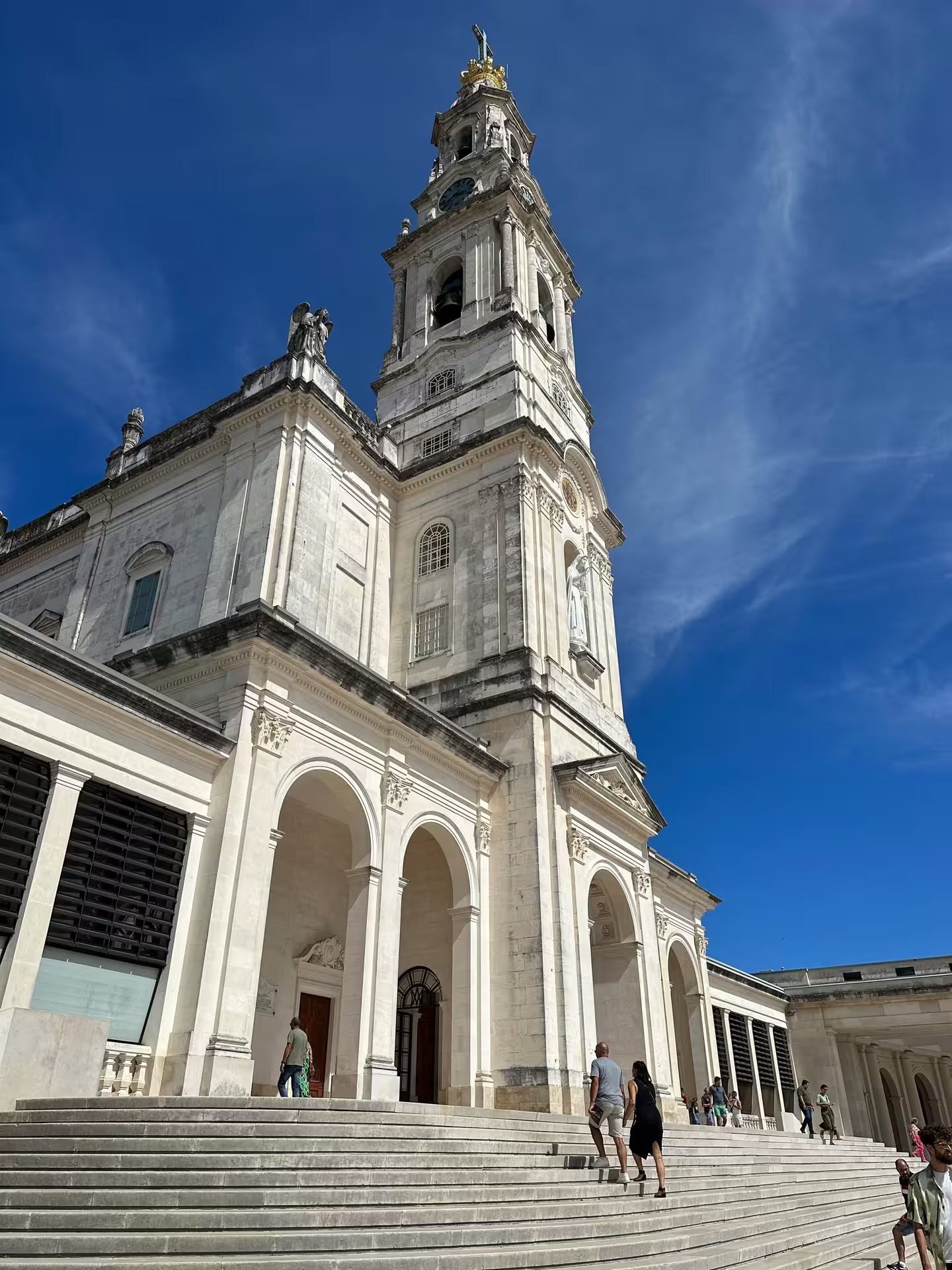 Majestic view of the Sanctuary of Fátima with its grand architecture and visitors, perfect for a spiritual Lisbon day tour.