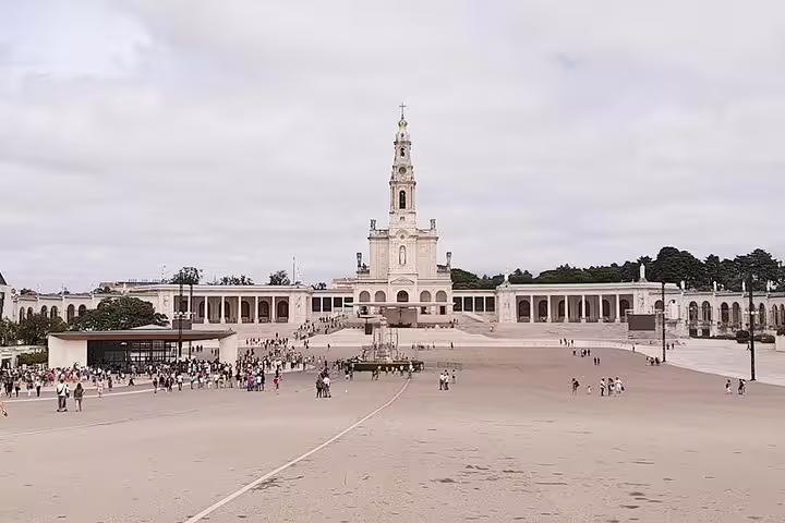 Expansive view of the Sanctuary of Fátima with visitors exploring its vast plaza, a highlight of the private tour.