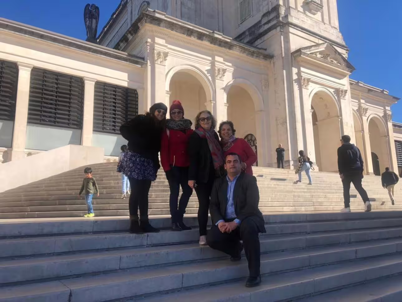Visitors enjoying a sunny day on the steps of the Sanctuary of Fátima, capturing memories at this iconic site.